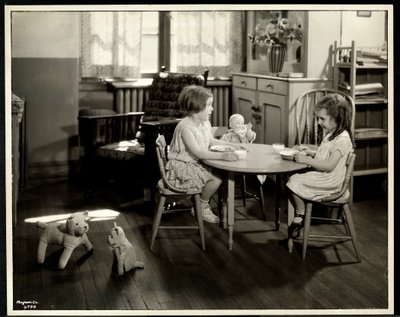 Dvě slepé zrakově postižené dívky jedí u malého stolku s panenkou v New York Association for the Blind, 111 East 59th Street, New York, 1933 (potisk stříbrnou želatinou) od Byron Company