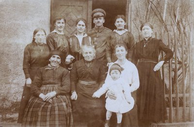 Anglický voják, WW1, se skupinou místních obyvatel, severní Evropa, pravděpodobně Francie (čb foto) od English Photographer