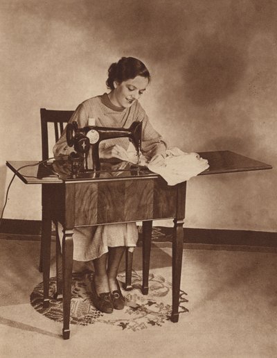 Hospodyně při práci na šicím stroji, polovina 30. let 20. století (čb fotografie) od English Photographer