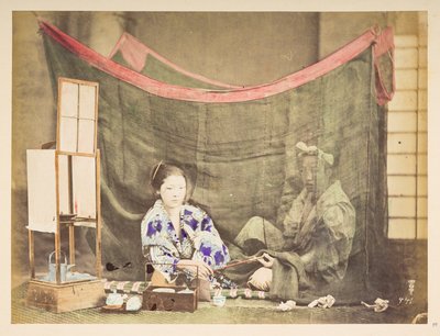 Japonský pár ve volném čase, Studiový obraz mladé Japonky, sedící s překážkou na přípravu čaje kolem sebe, podávající dýmku mužské postavě, která sedí za ní a je chráněna plátěnou moskytiérou,   Fotograf: Neznámý  Lucasova sbírka: od English Photographer