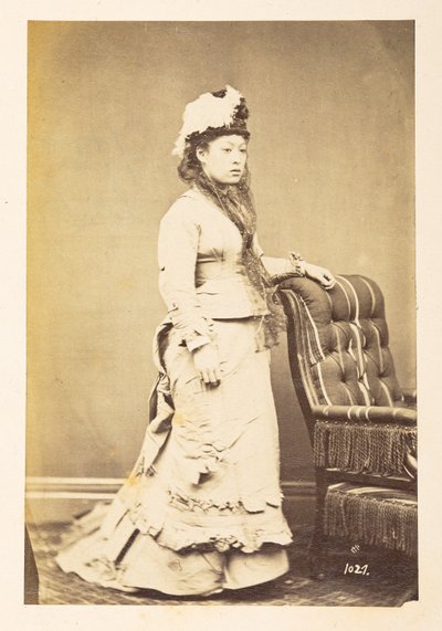 Japonka v evropských šatech, Celovečerní stojící studiový portrét mladé Japonky ve westernových šatech a klobouku,  Fotograf: Neznámý  Lucas Collection: Fotografický záznam světového turné Charlese Jamese a Mortona P, Lucase od English Photographer