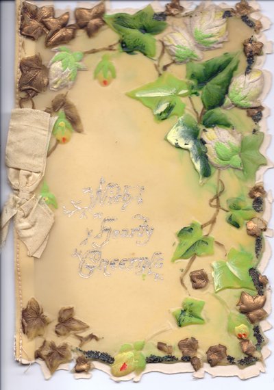 Přání vyrobené z plastu se zlatým a zeleným reliéfním břečťanem a béžovou mašlí, cca 1910 od English School