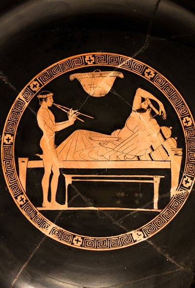 Pohár: symposiast a mladý otrok hrající na dvojitý aulos (červenofigurová keramika,) od Euaion painter