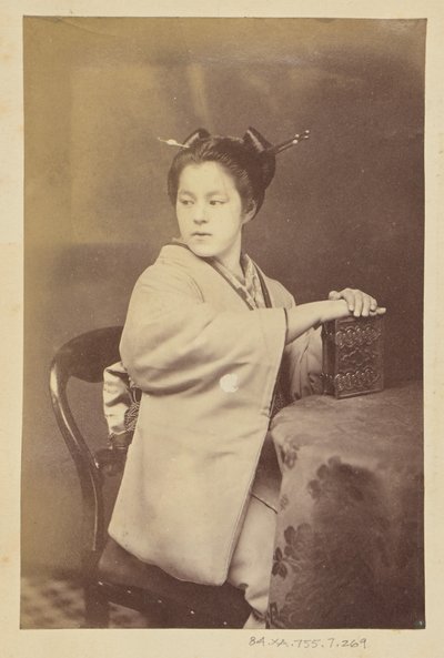 [Sedící Japonka držící u stolu album cartes-de-visite] od Felice Beato