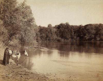 Muž v tradičním oděvu se svým koněm před jezerem v Egyptě od Félix Bonfils
