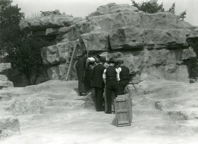 Skupina chovatelů vybaluje posvátné paviány mezi skalami „Monkey Hill“ v londýnské zoo od Frederick William Bond