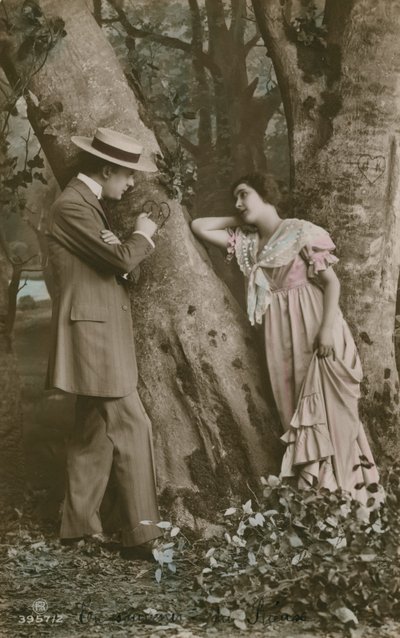Pohlednice milenců vyřezávajících srdce na stromě, zaslaná v roce 1913 (ručně kolorovaná fotografie) od French Photographer
