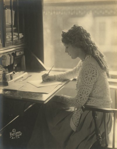 Mary Pickford píše u stolu, kolem roku 1918 (černobílá fotografie) od Bartolome Esteban and studio Murillo