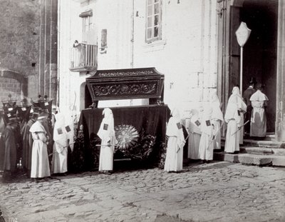 Smuteční průvod kongregace San Francesco v Neapoli. V popředí, před kostelem, doprovázejí četní „bratři z bratrstva“ v bílých tunikách a kápích katafalk zdobený vyšívanou látkou, na které je umístěna rakev. od Giorgio Sommer