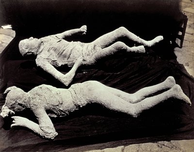 Dva odlitky lidských postav z vykopávek v Pompejích. Exponáty byly umístěny na černém plátně za účelem jejich fotografování od Giorgio Sommer
