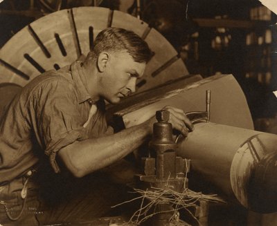 Muž s mikrometrem měřící hřídel na tisícinu palce. od Lewis W. Hine