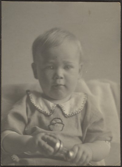 Dítě držící stříbrné chrastítko od Louis Fleckenstein