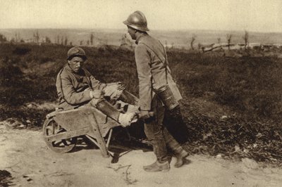 Zajatý francouzský voják převážející svého zraněného kamaráda na kolečku, první světová válka od Photographer German