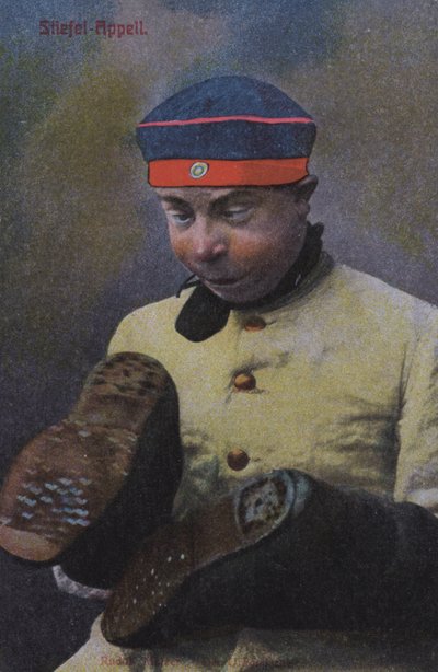 Německý voják při pohledu na podrážky svých bot (barevná fotografie) od Photographer German
