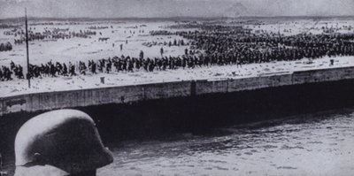 Německý voják provádějící průzkum spojeneckých zajatců na pláži u Dunkerque ve Francii, druhá světová válka, červen 1940 (černobílá fotografie) od Photographer German