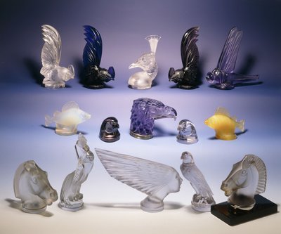 Různé skleněné maskoti aut (ptáků, ryb, koní a lidské hlavy) od Rene Jules Lalique