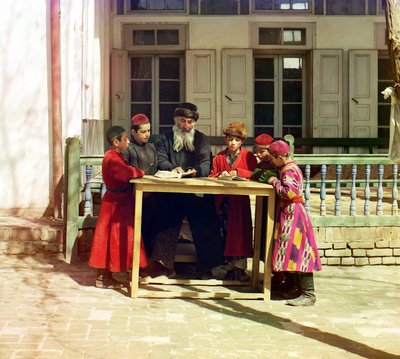 Skupina židovských dětí s učitelem na stole před domem, Samarkand, Ruská říše, mezi lety 1905 a 1915 od Sergey Prokudin Gorsky