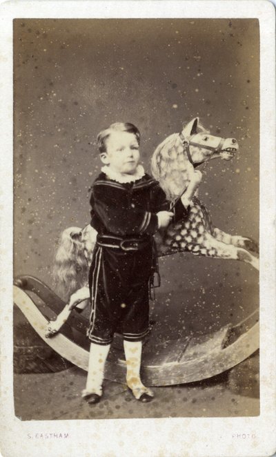 Chlapec stojící u houpacího koně od Silas Eastham