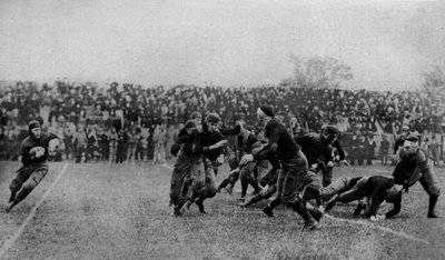 Severní Amerika. Hra ve středu hřiště na zápase amerického fotbalu. 1920 od Unbekannt