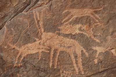 Skalní umění, Pravěk: Rytina antilopy napadené smečkou psů v masivu Uweinat v Egyptě (období 8000 až 3000 let před naším letopočtem). Fotografování od Unbekannt