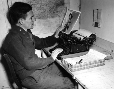 Druhá světová válka (1939-1945) – Druhá světová válka (2. světová válka nebo 2. světová válka): Mutzig (Alsasko) Francie 1. prosince 1944: Desátník Flanerty kronikář z Beachead News (zpravodajského deníku GI) se dívá na fotografii, kterou publikuje v příšt od Unbekannt