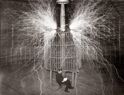 Nikola Tesla sedí ve své laboratoři v Colorado Springs se svým „zvětšovacím vysílačem“ od Unknown photographer