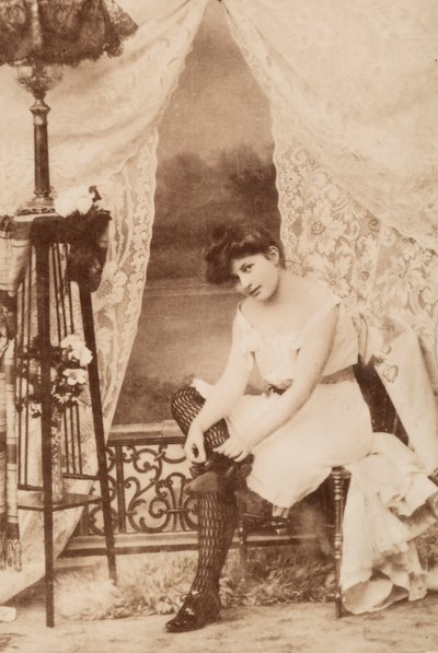 Portrét mladé ženy v intimním oděvu vsedě, jak si šněruje botu. od Unknown photographer