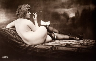 Portrét mladé ženy, která pózuje nahá, otočená zády a kouří cigaretu. od Unknown photographer