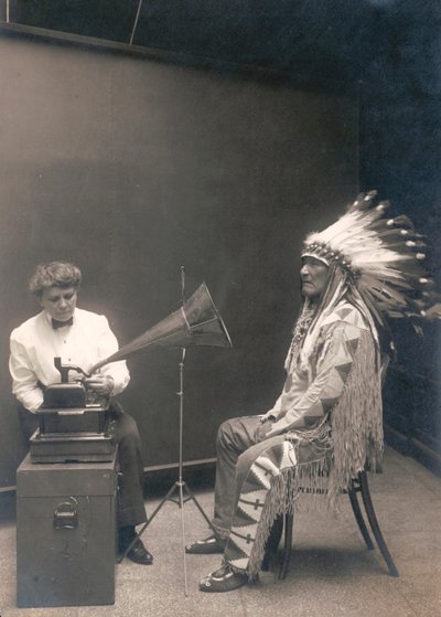 Piegan Indian, náčelník hory, poslouchá nahrávku s etnoložkou Frances Densmoreovou od . .