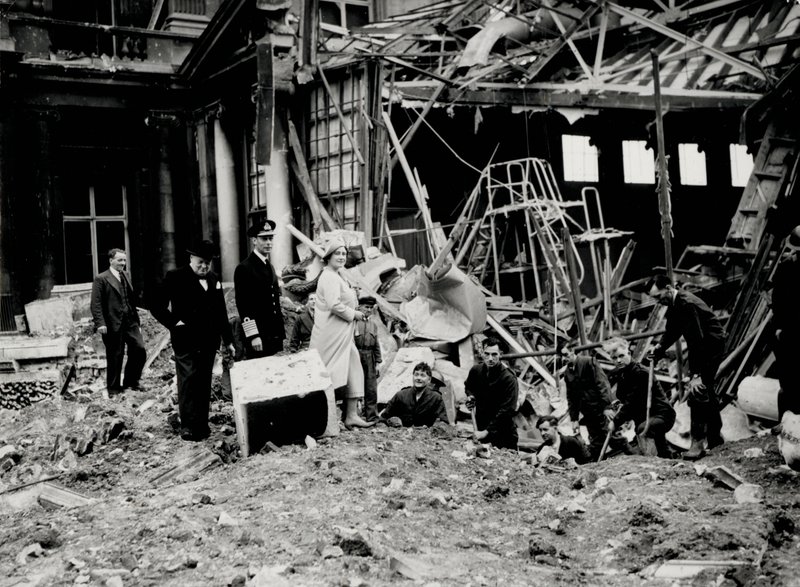 Král Jiří VI. a královna Alžběta spolu s Winstonem Churchillem zkoumají škody způsobené bombou, pravděpodobně do Buckinghamského paláce (černobílá fotografie) od English Photographer
