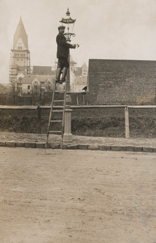 Muž po žebříku připevňující pouliční lampu (černobílá fotografie) od European Photographer