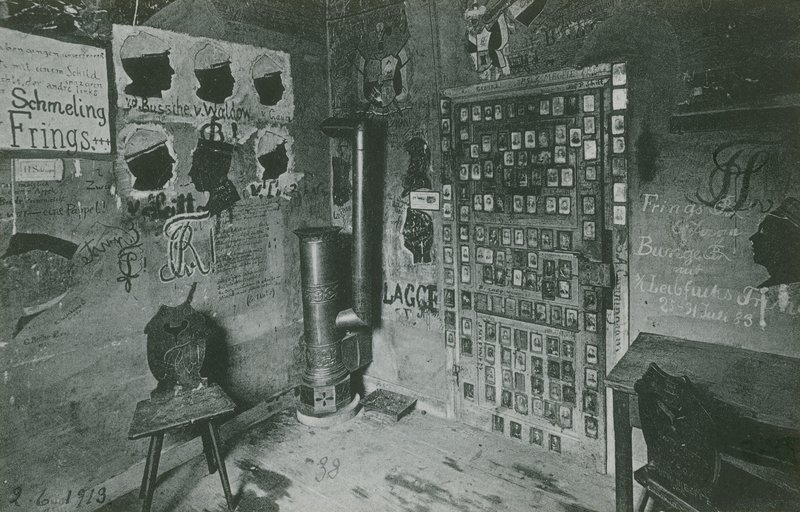 Místnost se stěnami pokrytými graffiti odkazujícími na významné osobnosti současnosti, jako jsou Bussche a Waldow. Pohlednice odeslaná v roce 1913. od German Photographer