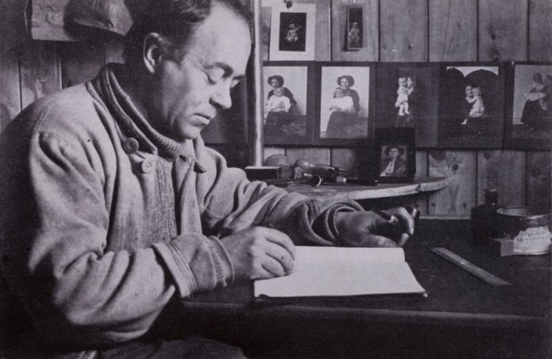 „Scott psal a plánoval a počítal u svého malého stolku“ (černobílá fotografie) od Herbert Ponting