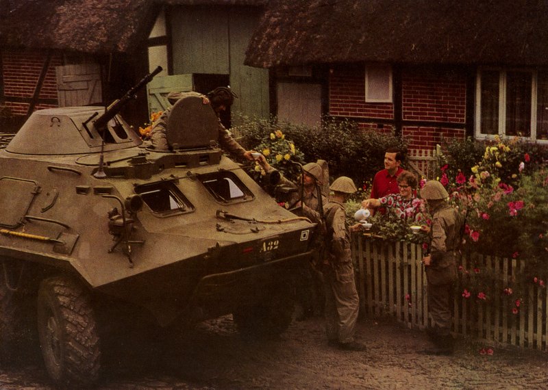 Při odpočinku na pochodu jsou obyvatelé srdečně vítáni vojáky Národní lidové armády (barevné foto) od Photographer German