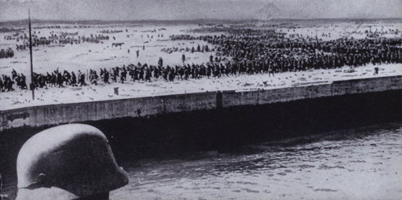 Německý voják provádějící průzkum spojeneckých zajatců na pláži u Dunkerque ve Francii, druhá světová válka, červen 1940 (černobílá fotografie) od Photographer German