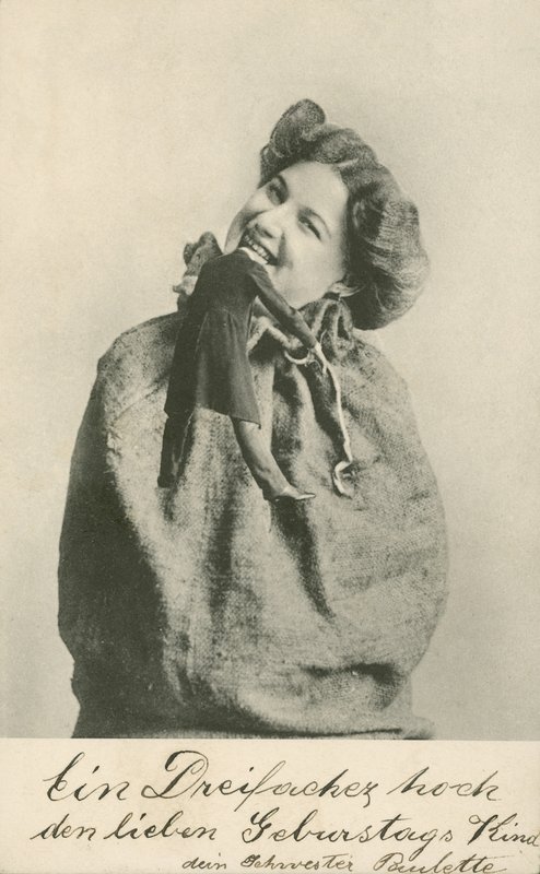 Žena kousající hlavu z panenky (černobílá fotografie) od Photographer German