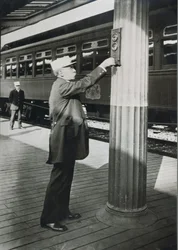 Průvodčí signalizující brzký odjezd vlaku „Royal Blue“ ve Washingtonu D.C. v roce 1910 (černobílá fotografie)