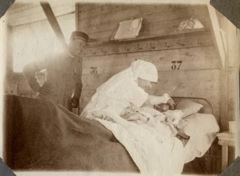 První světová válka 1914-1918: zdravotní sestra v blůze holí vojáka (francouzská válečná zranění leží v posteli), v Couville, Manche, Dolní Normandie (Dolní Normandie), Francie. Anonymní fotografie červenec 1917. Soukromá sbírka, Stella.