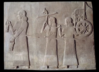 Umění Mezopotámie (Asýrie): dvůr paláce asyrského krále Sargona II. (721 - 705 př. n. l.) sloužících nesoucích situly a královský vůz. Paříž, Musee du Louvre