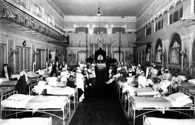 Vyzdobený salon v nemocnici s válečnými raněnými a sestrami Červeného kříže (č/b foto)