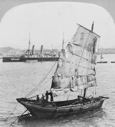 Čínský odpad a britská bitevní loď v přístavu v Hong Kongu, 1902