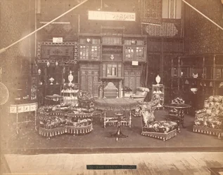 Expozice S. Howard & Sons -- hlavní budova, sbírka nábytku, včetně čalouněných židlí, stolů, krbu, skříní a polic. Na stěnách jsou koberce a na stolech a poličkách vázy