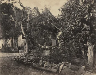 Venkovská scéna s kamennou budovou a křížem, c. 1857.