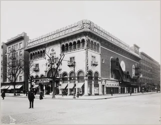 Obrovské divadlo s honosným průčelím, maurskými oblouky a balkony. Velký nápis na vrcholu budovy zní „B.S. Moss Regent Theatre Vaudeville & Feature Films“. Visí zde reklama na Olgu Petrovu ve filmu „The Heart of a Painted Woman“