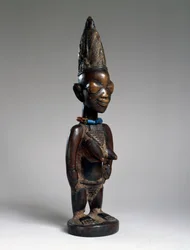 Postava dvojčete (ere ibeji), oblast Ila-Orangun, Nigérie, konec 19. nebo začátek 20. století (dřevo, skleněné korálky a stopy tukuly)