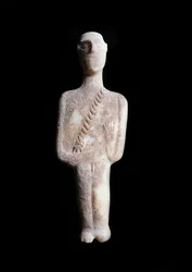 Mužský idol, schematická figurka. Socha z bílého mramoru s okrovými inkrustacemi, 3200-2000 př. Kr