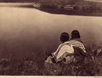 Hodina nečinnosti – Okamžik klidu: Indiáni Piegan sedí na okraji vodní plochy. Fotografie převzata ze svazku 6 encyklopedie vydané Edwardem S. Curtisem (1868-1952) o Indiánech Severní Ameriky, s předmluvou Theodora Roosevelta. B