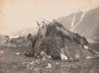 Inuitská chata a rodina, cca 1899 (černobílá fotografie)