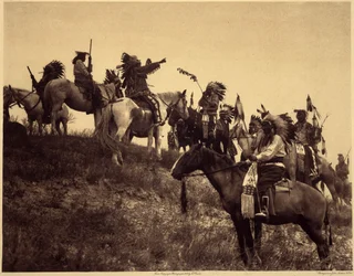 Plánování nájezdu. Indiáni se ve svých působivých typických kostýmech sdružují do mimořádně malebných skupin. Toto je jednotka ze Sioux Ogalala (Oglala), na kopci s výhledem na údolí Wounded Knee v rezervaci Pine Ridge v Jižní Dakotě. Fotografie pořízená