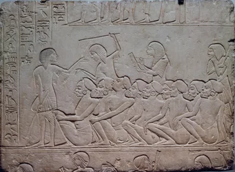 Černí vězni obklopení ozbrojenými strážemi, reliéf z memfidské hrobky Haremheba v Sakkáře, egyptská civilizace, Nová říše, XVIII. dynastie